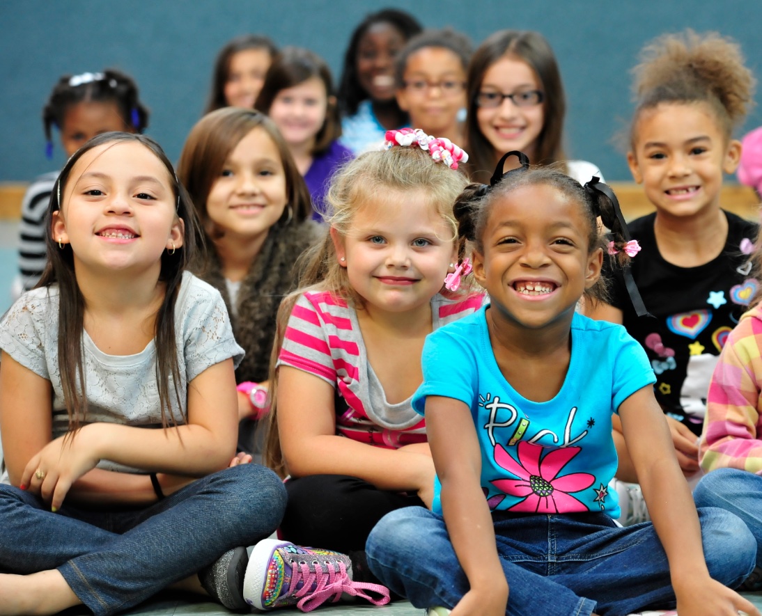 Young elementary students laughing during a school magic assembly